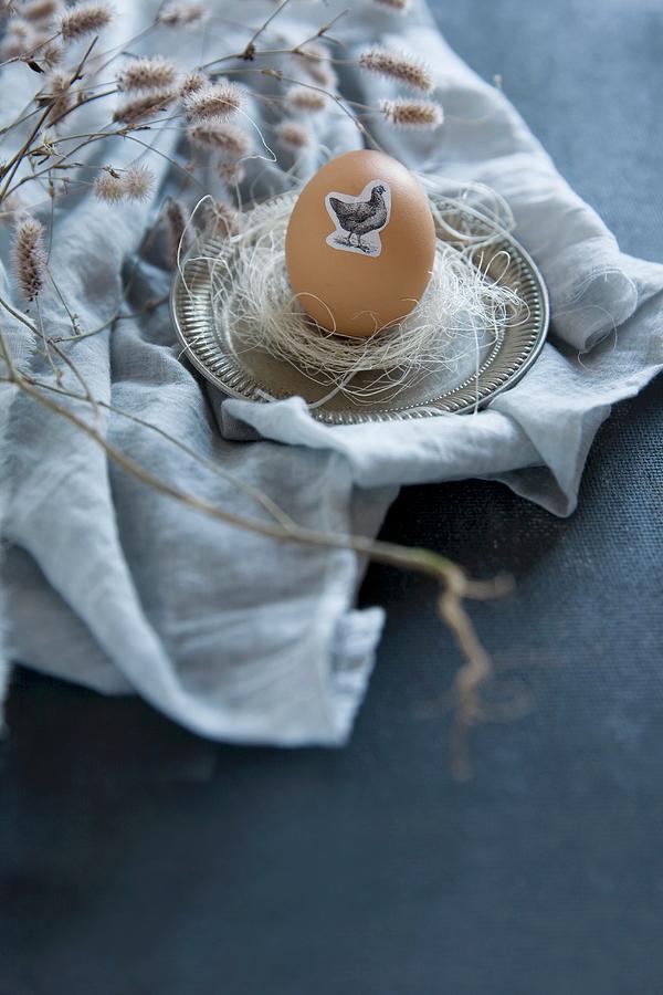 Easter Egg Decorated With Animal Sticker On Pewter Saucer Photograph by Alicja Koll