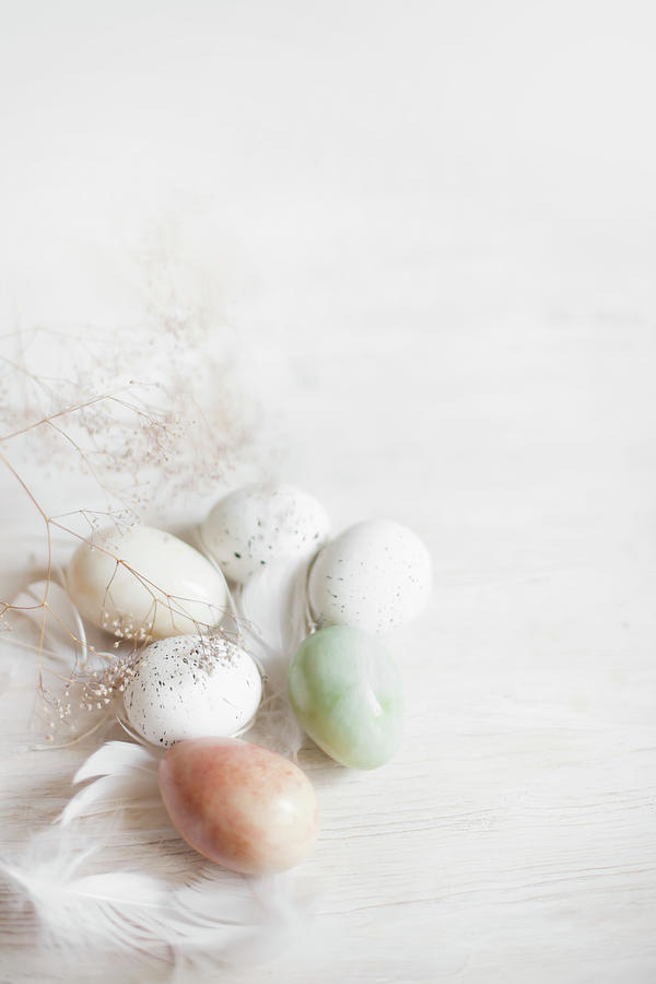 Easter Eggs And Feathers On White Wooden Surface Photograph by Alicja Koll