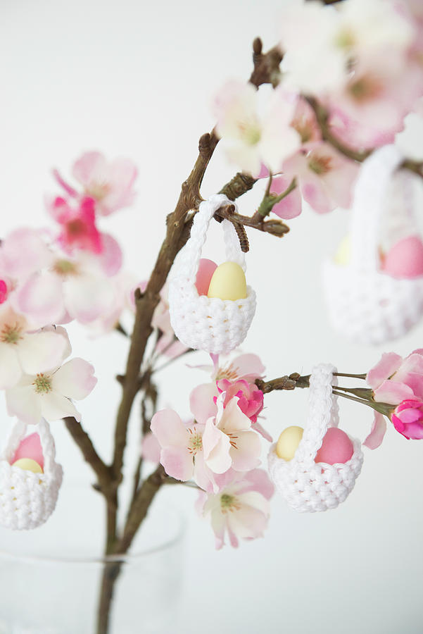 Easter Eggs In Crocheted Baskets Hung From Flowering Branch Of Fruit Tree Photograph by Ruud Pos