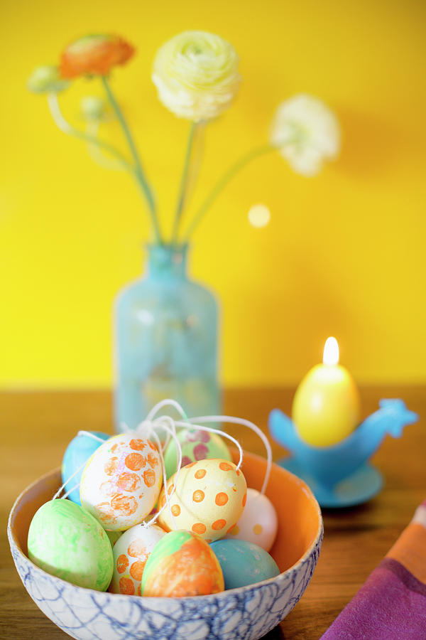 Easter Eggs Painted With Gouache In Front Of Candle And Flowers Photograph by Iris Wolf