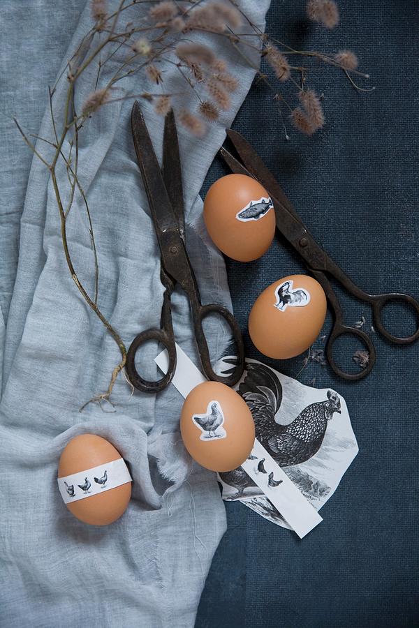 Easter Eggs With Animal Motif Stickers On A Blue Cloth With Vintage Scissors Photograph by Alicja Koll