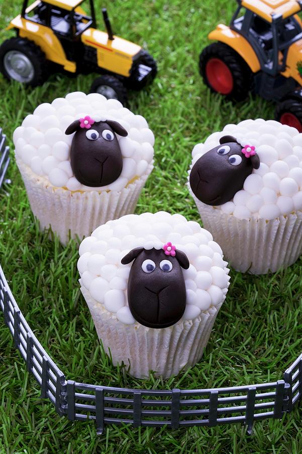Easter Lamb Cupcakes And Toy Tractors On A Grass Surface Photograph by Adrian Britton