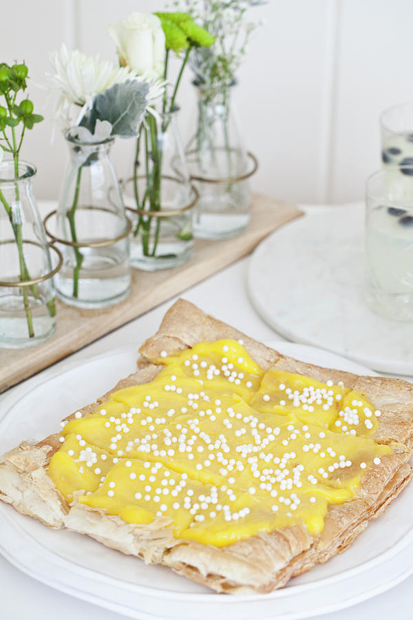 Easter Lemon Curd Puff Pastry Tart Topped With Sugar Pearls On A White Plate With Flowers And Lemonade With Blueberries Photograph by Ryla Campbell