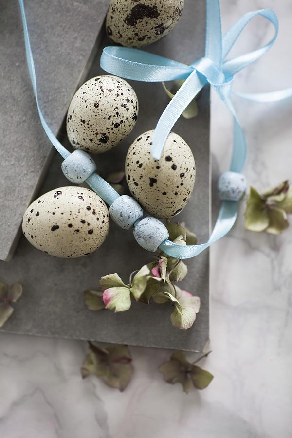 Easter Still-life Arrangement Of Quail Eggs, Beads On Ribbon & Hydrangea Florets Photograph by Alicja Koll