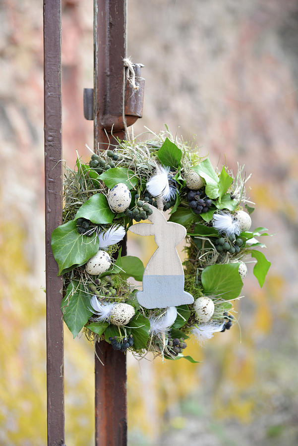 Easter Wreath Wrapped In Moss, Hay, And Ivy, Decorated With Quail Eggs, Chicken Feathers, And A Wooden Rabbit Figure Photograph by Daniela Behr
