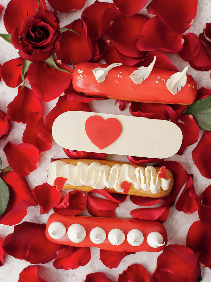 Eclairs With Decorations And Red Rose Petals Photograph by Kuzmin5d