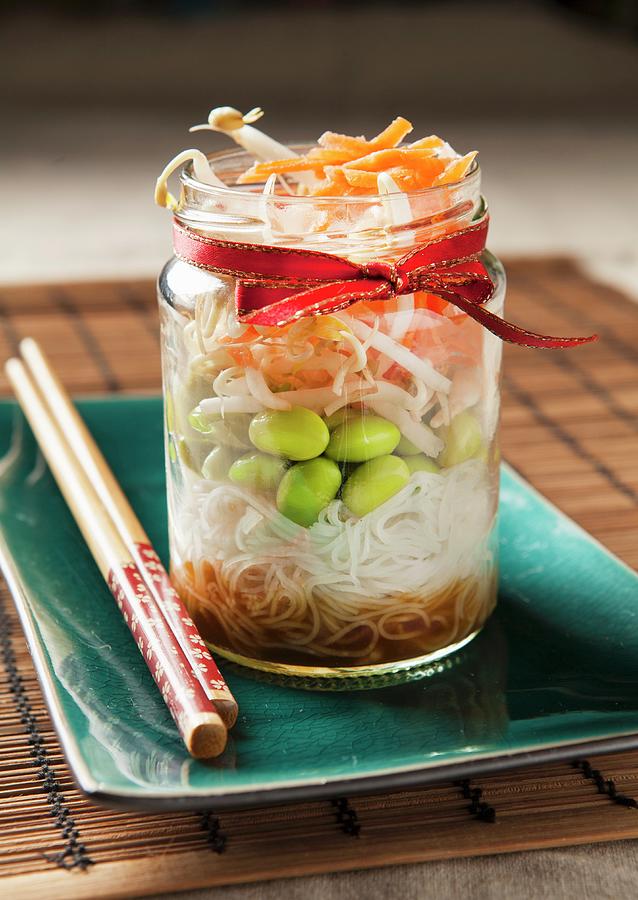 Edamame Bean Salad In A Trendy Lunch Jar With Chopsticks On A Teal Plate And Bamboo Mat Photograph by Stacy Grant