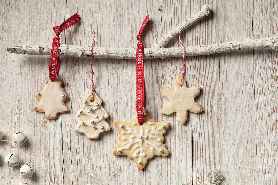 Edible Iced Christmas Tree And Snowflake Shaped Biscuits Hanging By Noel Red Ribbon And Bakers Twine From A White Branch Photograph by Stacy Grant