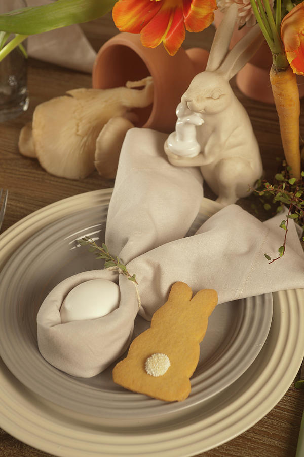 Egg Wrapped In Napkin Folded Into Bunny Ears And Biscuit On Easter Table Photograph by Great Stock!
