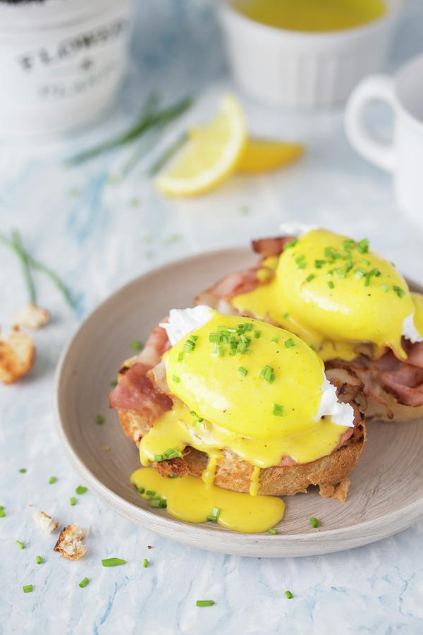 Eggs Benedict poached Eggs With Crispy Bacon And Hollandaise Sauce On A Toasted Bread Photograph by Malgorzata Laniak