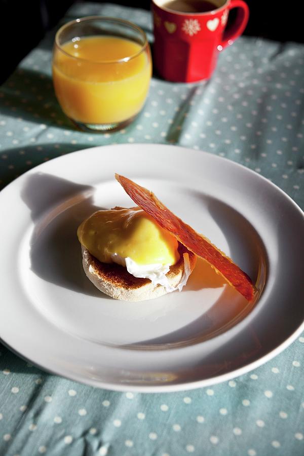 Eggs Benedict With A Slice Of Crispy Parma Ham On A Breakfast Table Photograph by