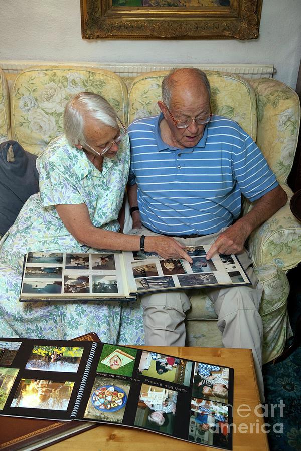 Elderly Couple Looking At Family Photos Photograph by Mark Thomas/science Photo Library