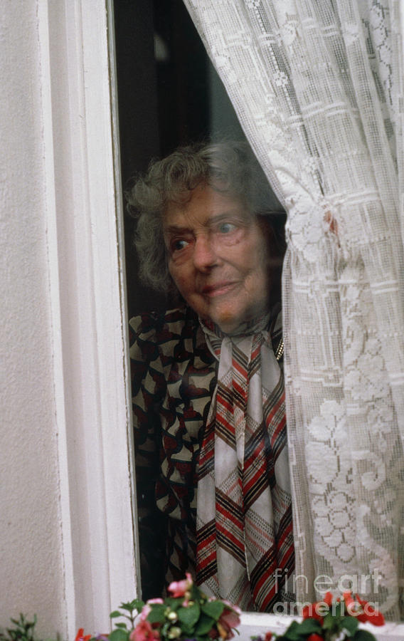 Elderly Lady Peering Out Of House Window Photograph by Mark Clarke/science Photo Library