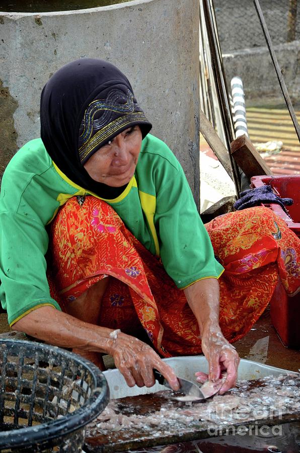Elderly Thai Muslim woman in sarong and headscarf guts and cleans fish Pattani Thailand Photograph by Imran Ahmed