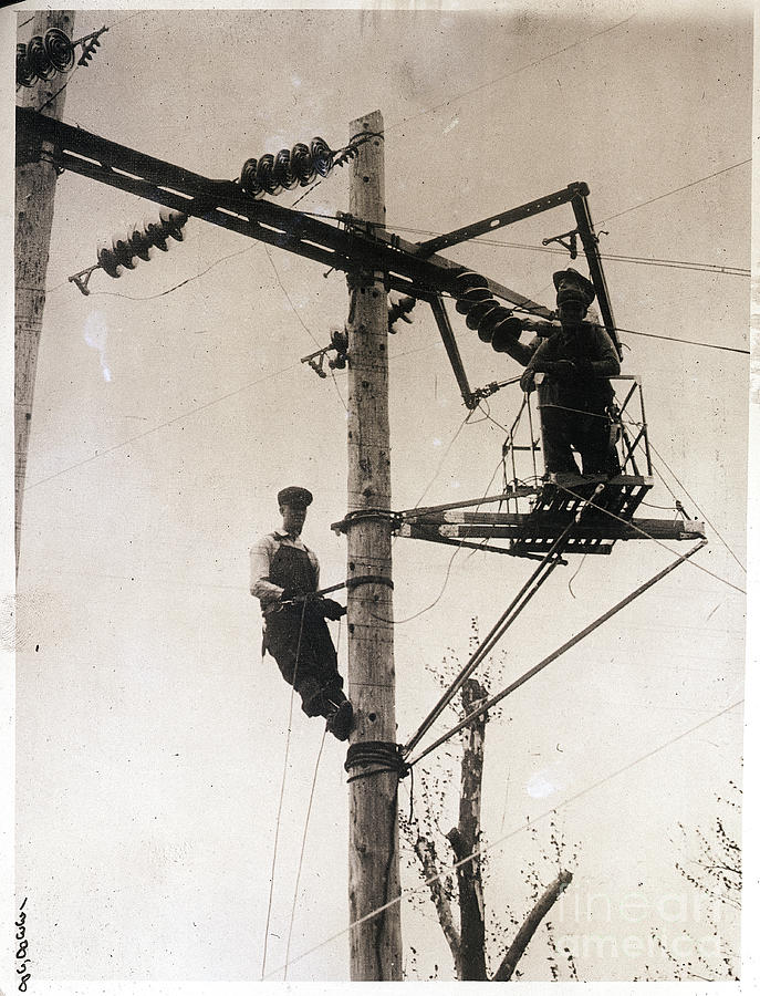 Electrical Line Workers On Pole Platform Photograph by Bettmann
