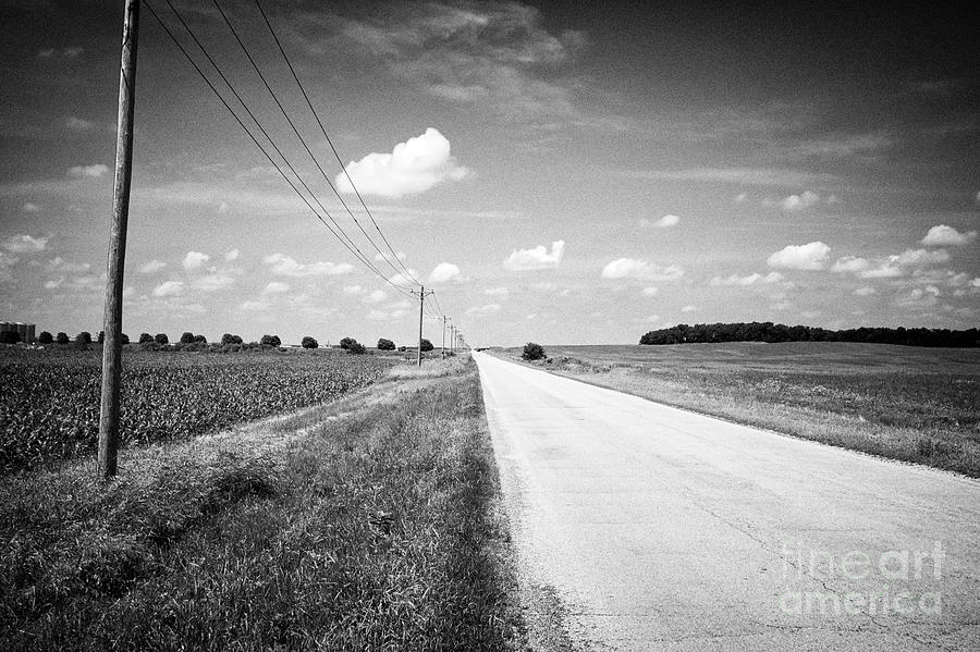 electricity wires and small local rural road through flat northern ...