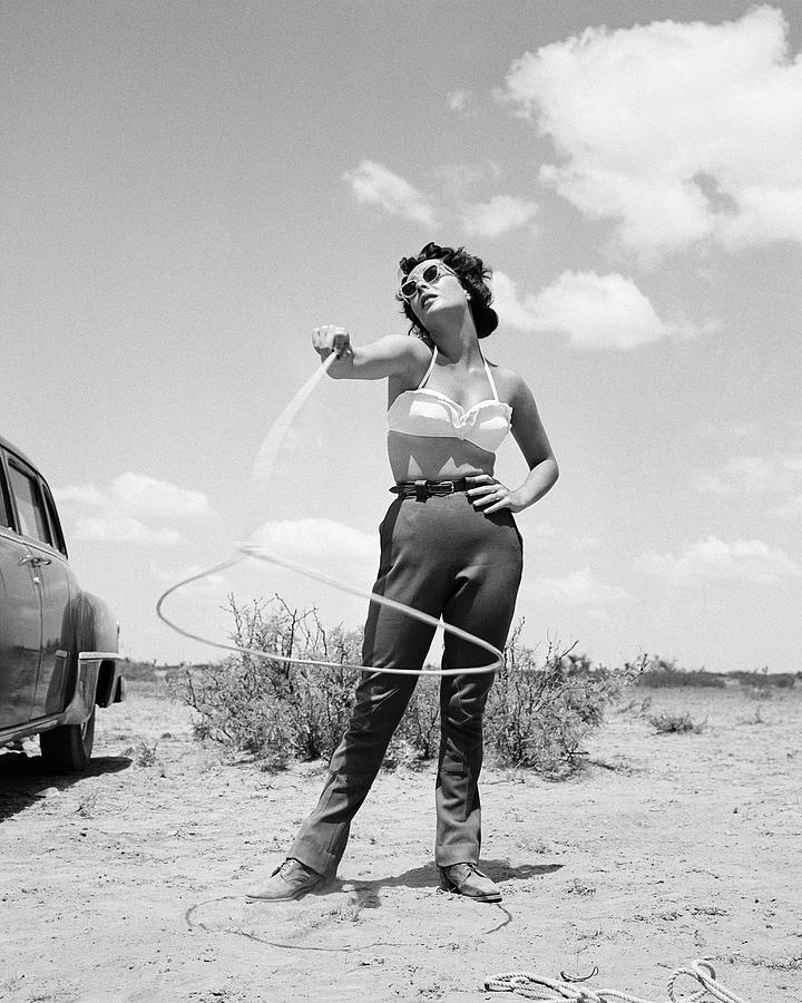 1955 Photograph - Elizabeth Taylor Spinning Lasso On The Set Of Giant by Frank Worth