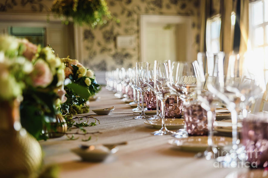 Elongated table with all the cutlery elegantly arranged and beautiful centerpieces ideal for decorating a wedding. Photograph by Joaquin Corbalan