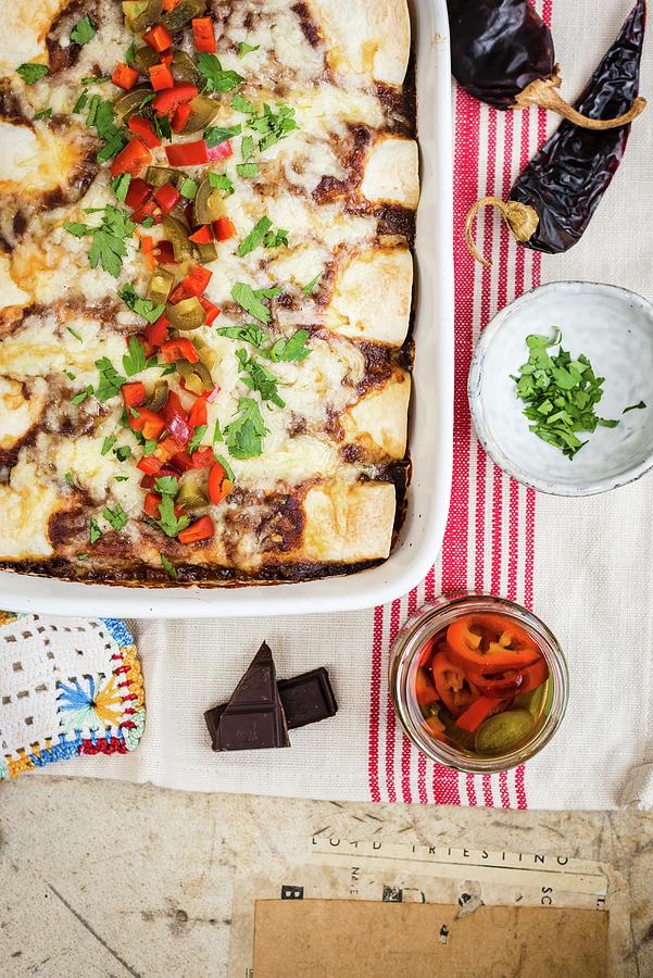 Enchiladas With Pork And Mole Sauce In A Baking Dish With Pickled Jalapenos Photograph by Lucy Parissi