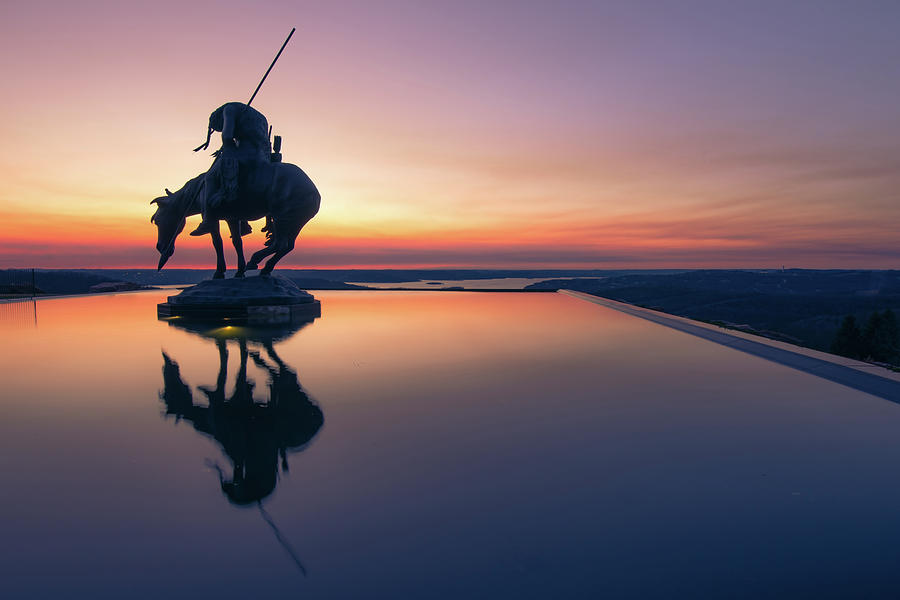 Still Life Photograph - End of the Trail Statue Silhouette - Top of the Rock Sunset Reflections by Gregory Ballos