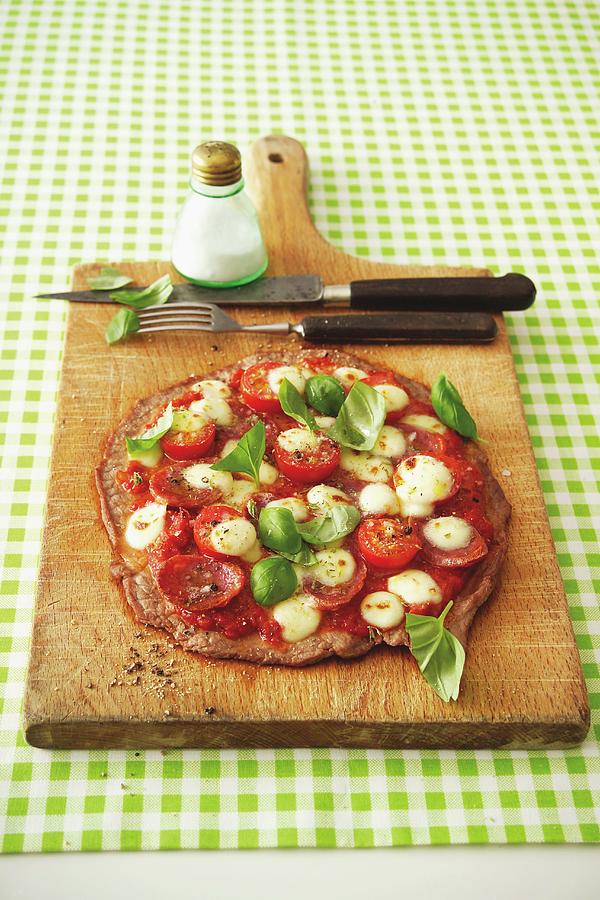Escalope Pizza Topped With Salami, Tomatoes And Moozzarella Photograph by Michael Wissing
