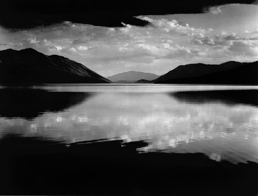 Evening, Lake McDonald, Glacier National Park w. clouds and mountains reflecting in the lake at dusk. Photograph by Ansel Adams
