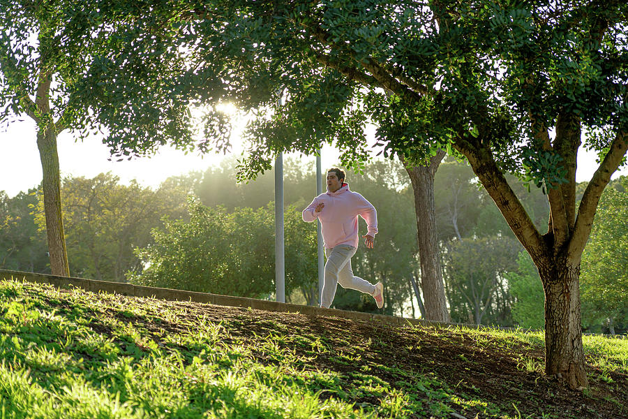 Fat Man Sprinting In The Park With Sunset Light Photograph by Cavan ...