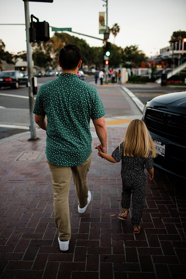 father and daughter holding hands walking