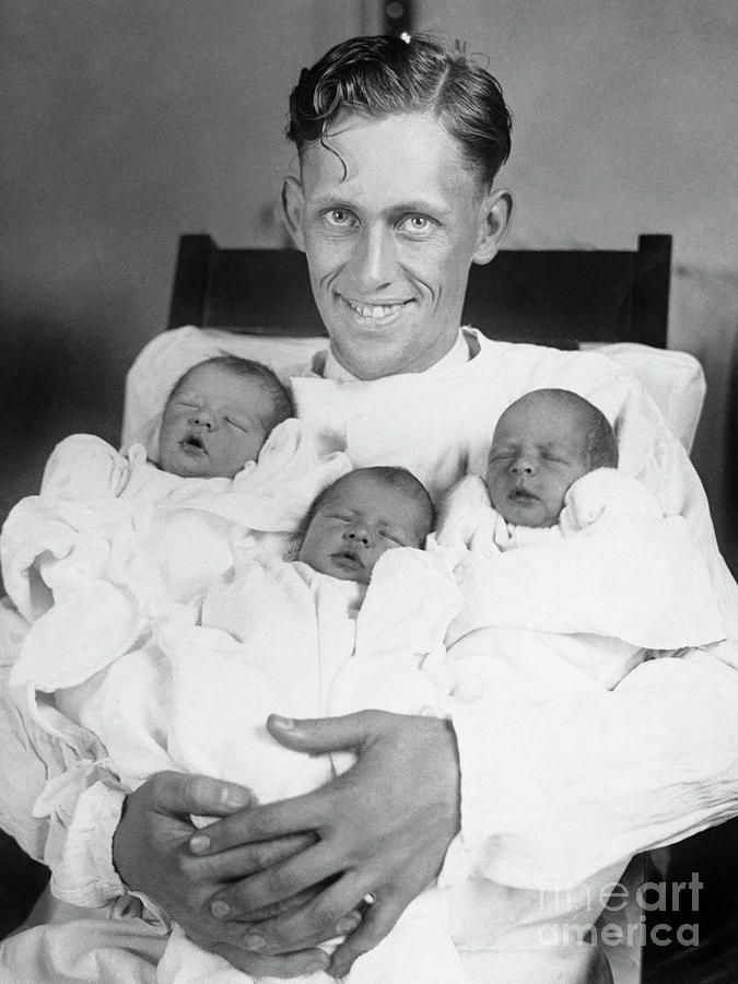Father Holding Newborn Triplet Sons Photograph by Bettmann