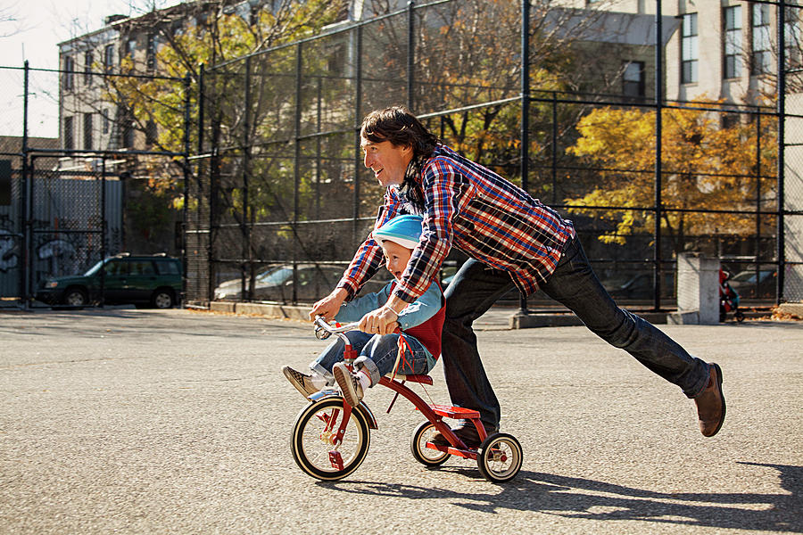 Father Pushing Son On Tricycle At Park Photograph by Cavan Images ...