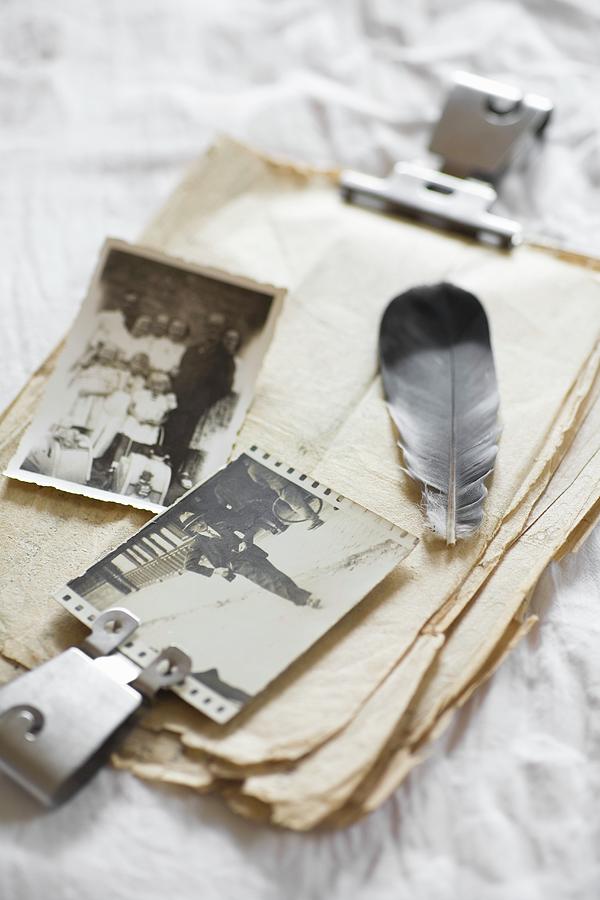 Feather And Old Photos On Stack Of Vintage Paper Photograph by Alicja Koll