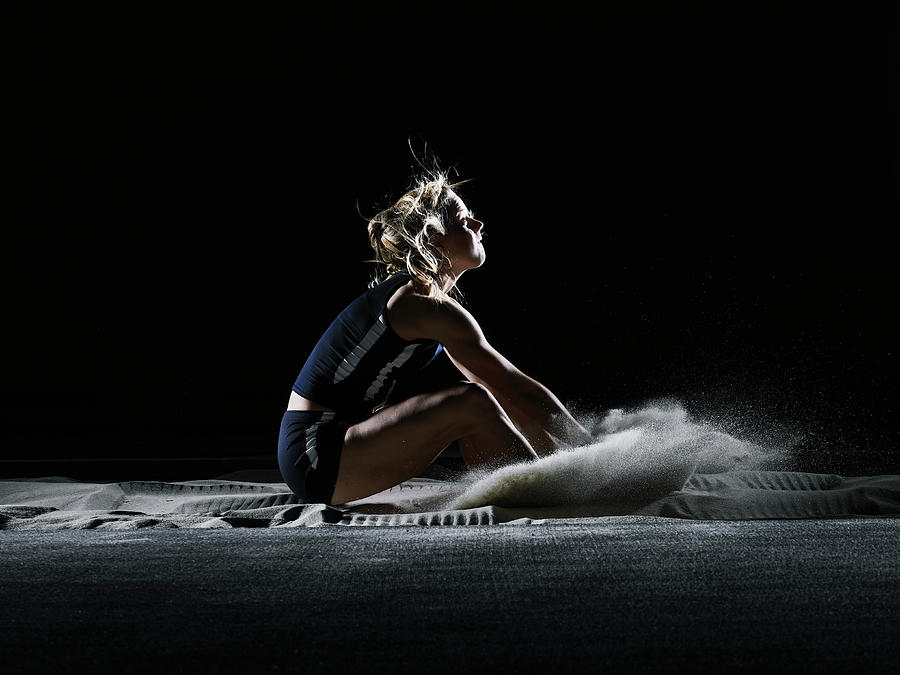 Female Athlete Landing In Long Jump Photograph by Thomas Barwick