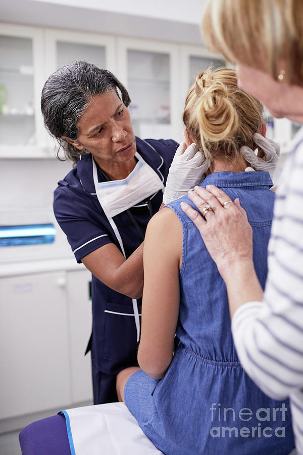 Female Doctor Examining Girl Patient In Examination Room Photograph By