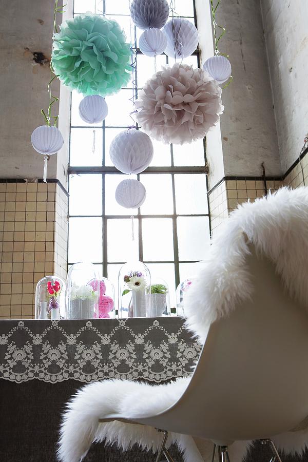 Feminine, Romantic Party Decorations; Pompoms, Nostalgic Lace Tablecloth And Flower Arrangements On Dining Table In High-ceilinged, Disused Factory With Industrial Windows Photograph by Nikky Maier