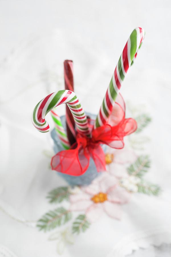 Festive Candy Canes Tied With Ribbon Arranged In Glass Photograph by Mandy Reschke