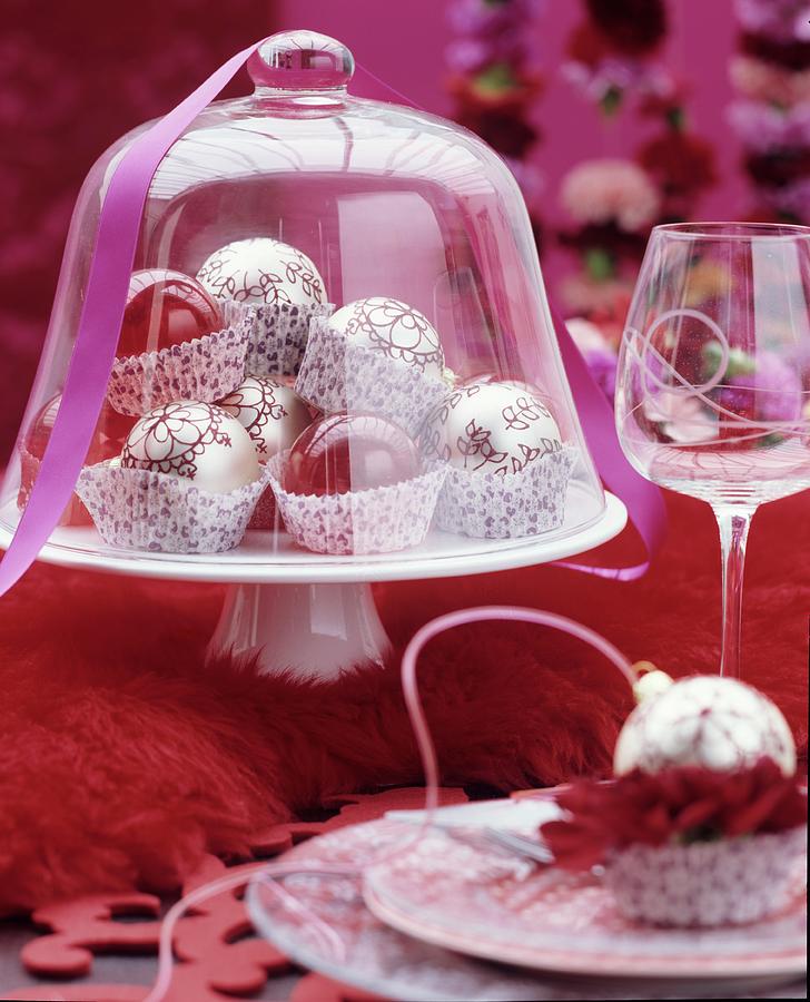 Festive Table Arrangement Of Christmas Tree Baubles In Paper Cake Cases Under Glass Cover Photograph by Matteo Manduzio