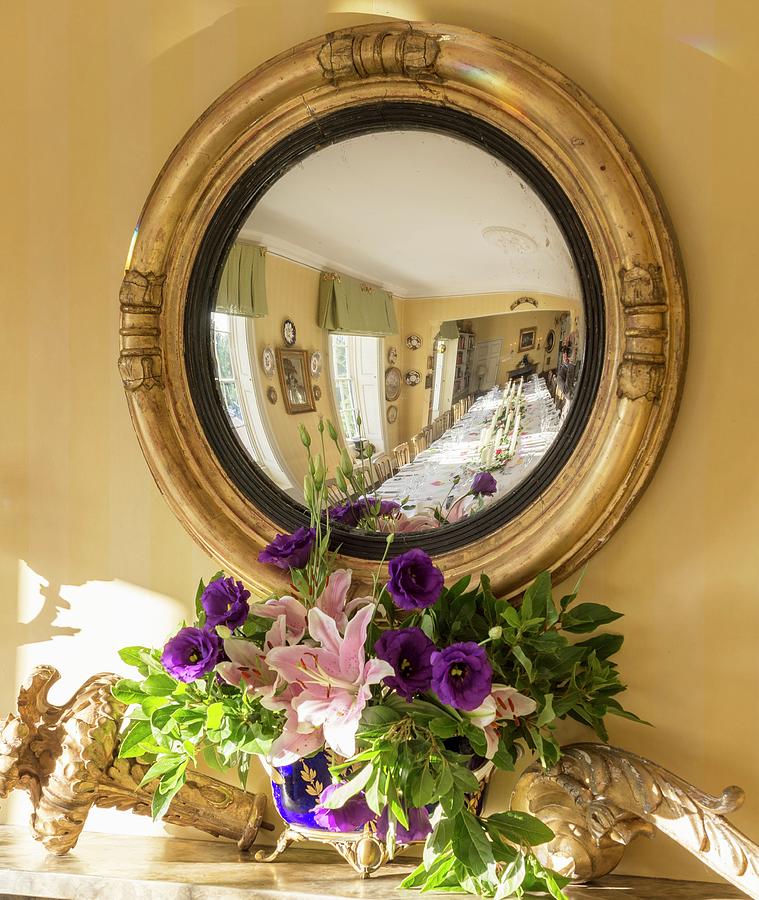 Festively Set Dining Table Reflected In Antique Convex Mirror Above Mantelpiece In Dining Room Of Private House In Suffolk, England Photograph by Brian Harrison