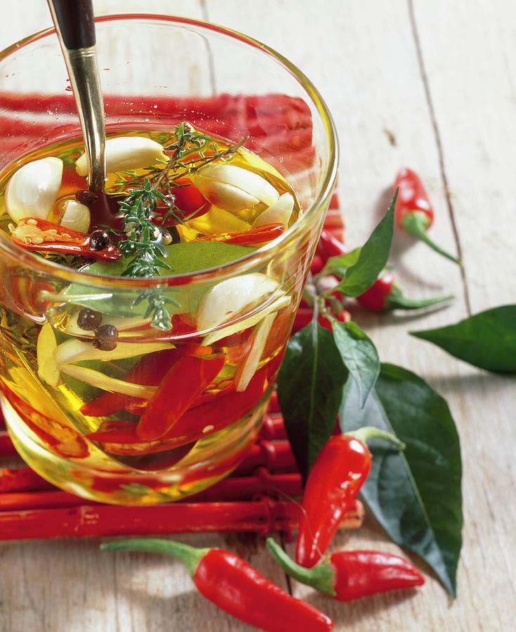 Fiery And Spicy Olive Oil With Chili, Garlic, Thyme, Laurel And Allspice Photograph by Teubner Foodfoto