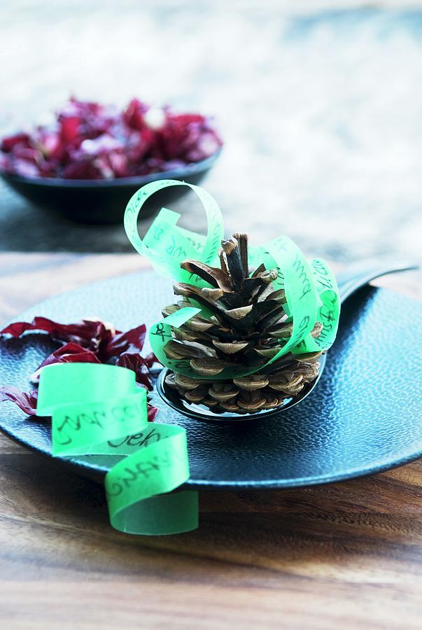 Fir Cones And Green Ribbon Used As Menu On Blue Plate Photograph by Matteo Manduzio
