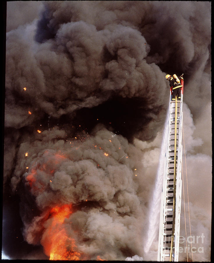 Fire Fighter Hosing A Fire From A Ladder Photograph by George Post/science Photo Library