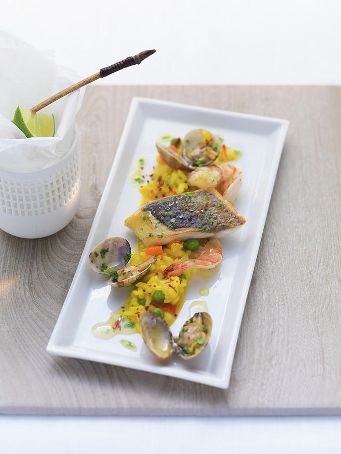 Fish And Seafood On Saffron Rice Photograph by Eising Studio