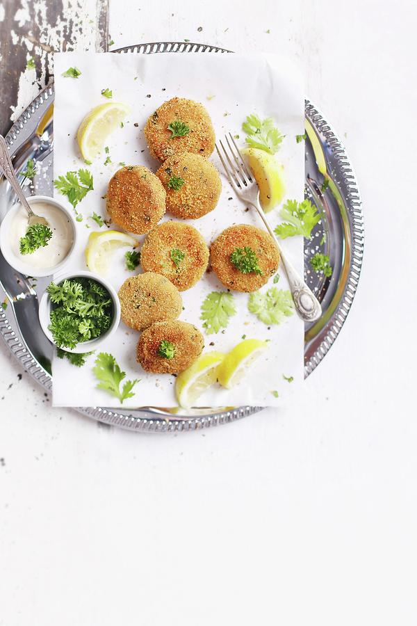 Fish Burgers With Lemon Wedges And Parsley On A White Table Photograph by Natalia Mantur