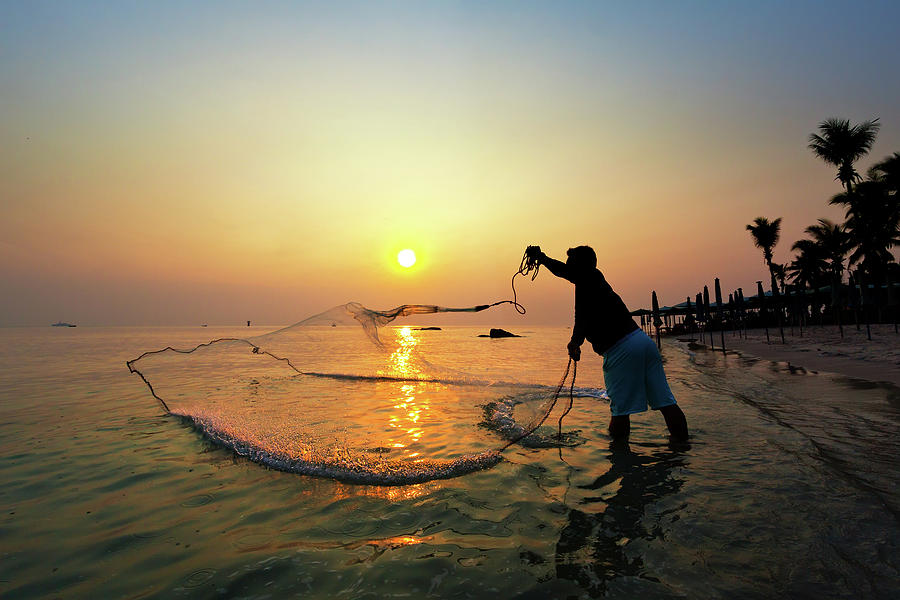 Fisherman Catching A Fish Photograph by Monthon Wa