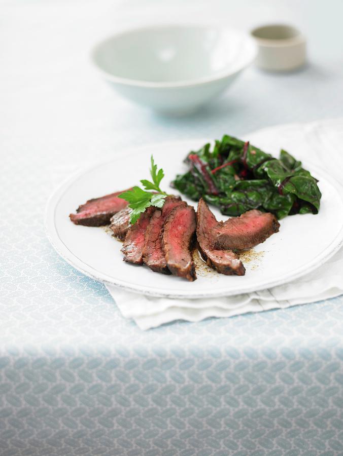 Flank Steak With Leafy Greens Photograph by Leigh Beisch