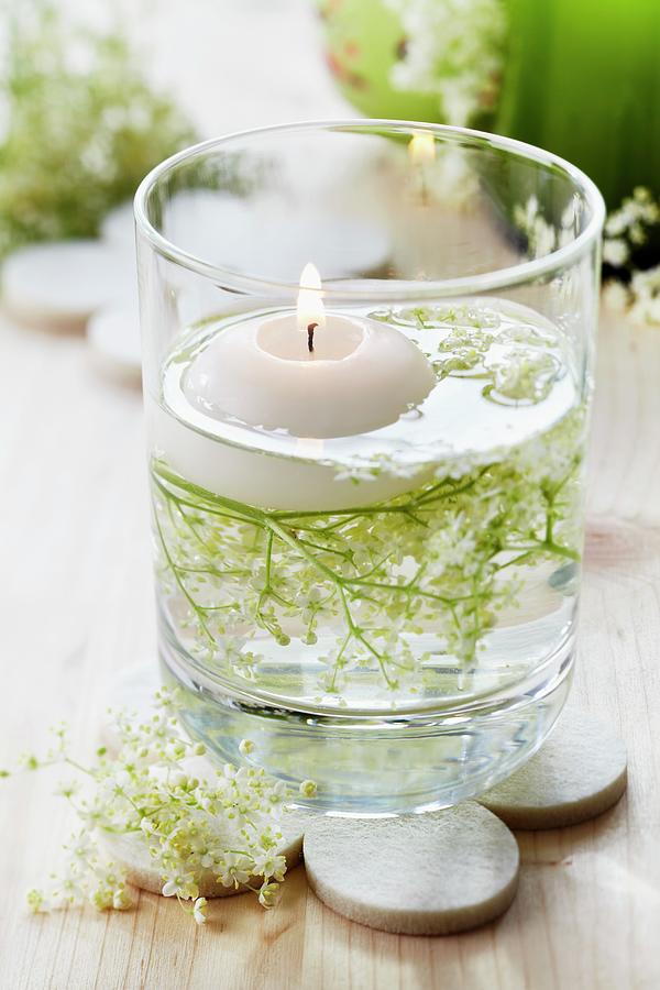 Floating Candle And Elderberry Flowers In Glass Photograph by Franziska Taube