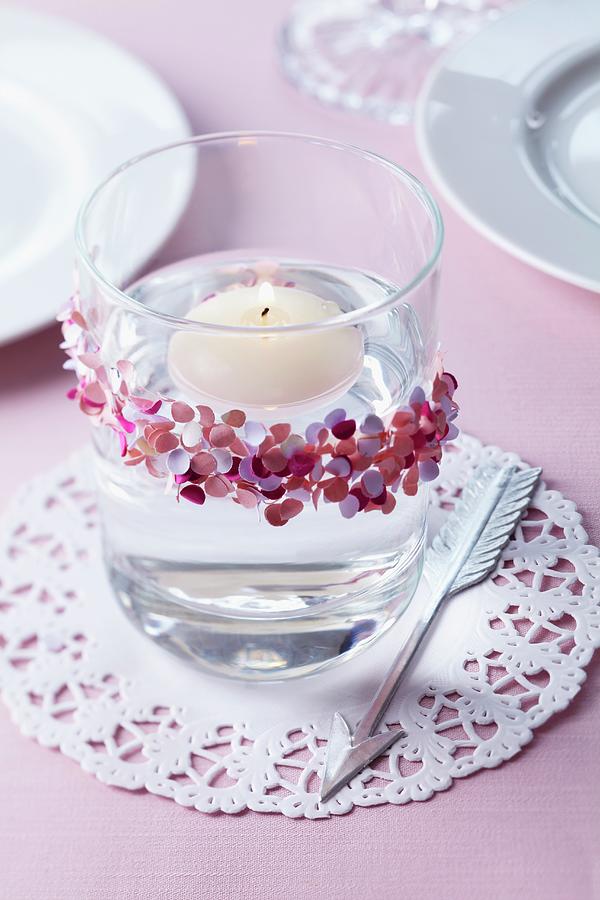 Floating Candle In Glass Decorated With Confetti On Doily Photograph by Franziska Taube