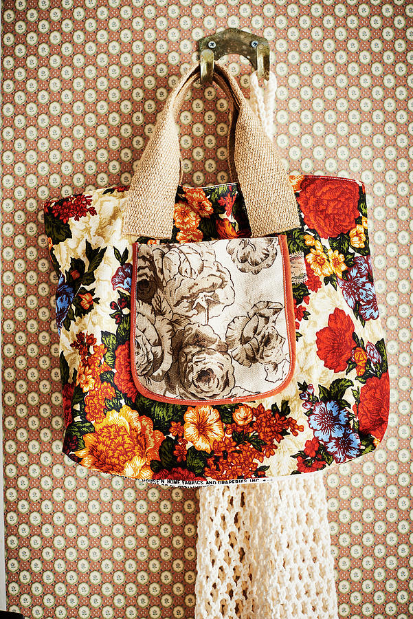 Floral Shopping Bag Hung On Hook On Patterned Wallpaper Photograph by Catherine Gratwicke