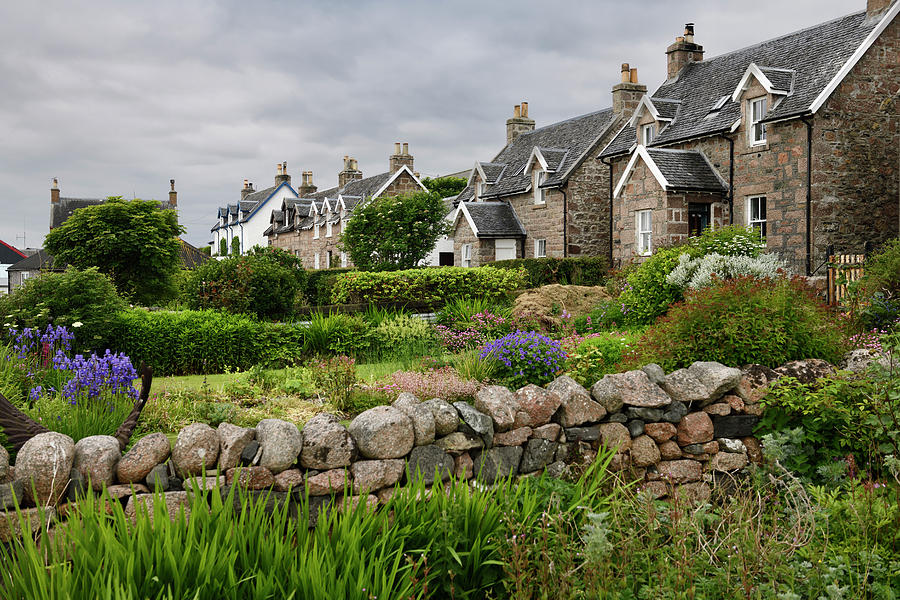 Flower gardens under cloudy sky with stone houses of Baile Mor v Photograph by Reimar Gaertner