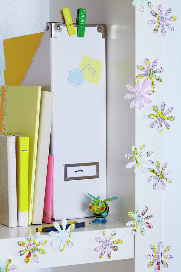 Flower Shapes Punched Out Of Map Decorating White Shelving Photograph by Franziska Taube