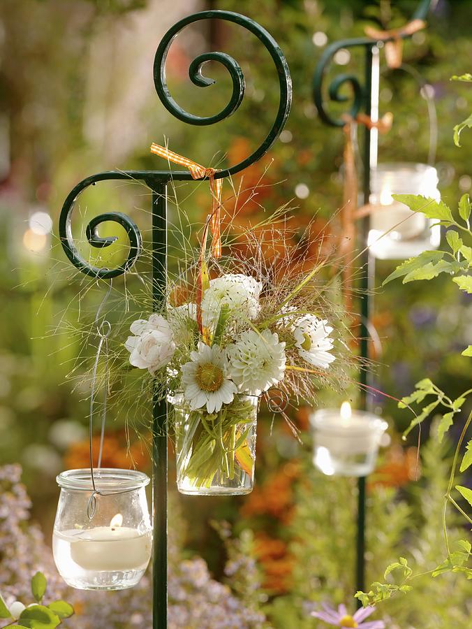 Flowers And Candles In Jars Hanging On An Ornamental Post Photograph by Friedrich Strauss